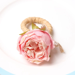 Pink artificial rose napkin ring with rustic straw base for elegant wedding table decor
