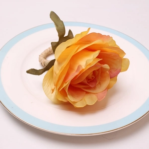 Detailed close-up of a gradient yellow peony napkin ring on a white ceramic plate