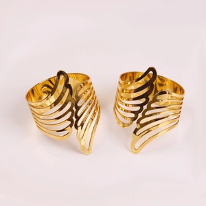 Close-up of elegant gold angel wing napkin rings with detailed hollow feather design