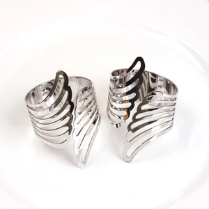 Macro shot of silver metal napkin ring with hollowed-out angel wing leaf design details