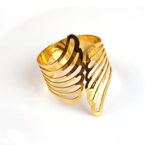 Detail of a hollow wing napkin ring in a bright golden finish for elegant table settings
