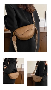 Detail of vintage brown saddle bag with gold buckle and colorful jacquard wide strap