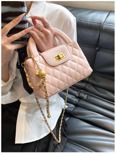Detailed shot of pink quilted bag with golden chain and adjustable metal ball buckle