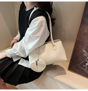 Detail of cream white faux leather tote bag with heart-shaped coin purse accessory