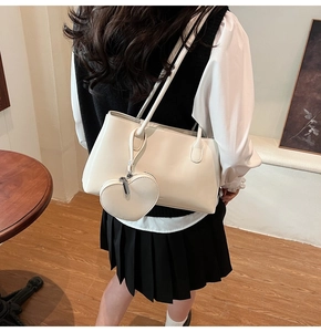 Detailed view of creamy white oil wax leather tote bag with heart-shaped coin purse