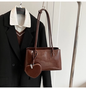 Detail of vintage brown Boston bag with smooth leather finish and heart charm