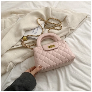 Detailed view of pink quilted handbag with gold chain strap and metal twist lock