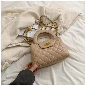 Detail of beige quilted leather handbag with gold chain strap and metal turn-lock