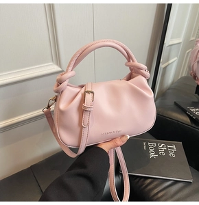 Close-up of pink ruched bucket bag with knot handle and Fashion & Bags gold lettering