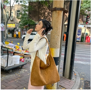 Brown suede tote bag shown on a model in a casual street setting for autumn commute