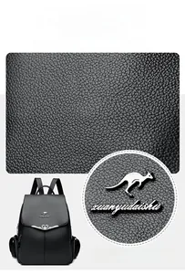 Close-up of black litchi pattern leather backpack with metallic logo and textured fabric