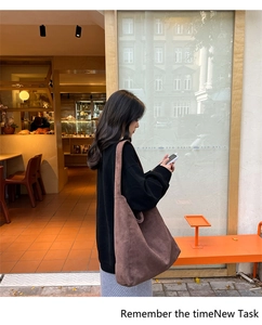 Brown oversized suede tote bag shown in a stylish outdoor street photography setting
