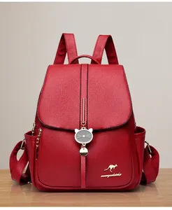 Detail of soft dark red pebbled leather backpack with gold kangaroo emblem and cat charm