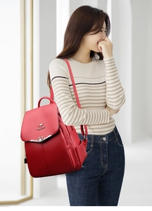 Detail of red faux leather backpack featuring heart-shaped lock and kangaroo logo