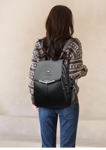 Black leather backpack on model featuring kangaroo logo and heart-shaped cutout