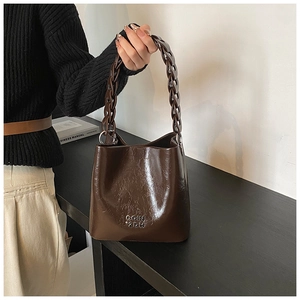 Détail du sac seau en cuir ciré vintage avec bandoulière chaîne et relief COIN 2DH
