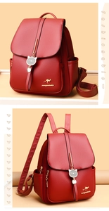 Detail of red pebbled leather backpack featuring kangaroo logo and cat charm pendant