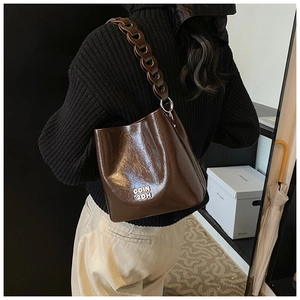 Détail du sac seau en cuir ciré vintage avec chaîne argentée et lettrage COIN 2DH