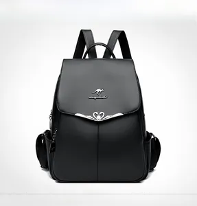 Close-up of black lychee grain leather backpack featuring a metal kangaroo logo and heart charm