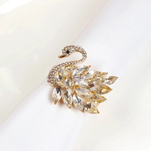 Close-up of golden swan napkin ring with sparkling crystals for elegant wedding decor