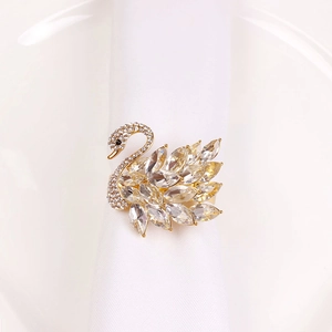 Detail of luxury swan napkin ring with champagne crystals on a white fabric napkin