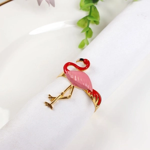 Pink flamingo napkin ring with gold finish on white cloth for elegant table decor