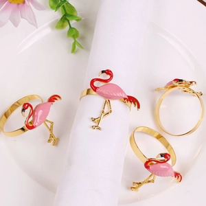 Close-up of pink flamingo napkin rings set on white linens for elegant table decor