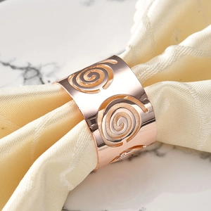 Vue macro de l'anneau de serviette en spirale or rose sur nappe pour décoration