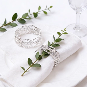 Macro shot of silver woven napkin ring on elegant white dinnerware and linen setup