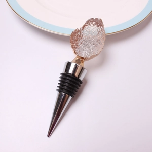 Close-up of pink druzy wine stopper with gold rim and silver metal cone base