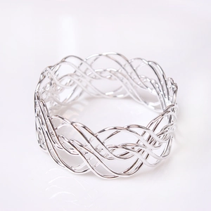 Macro shot of silver woven napkin ring showing detailed metallic hollow braid texture