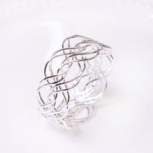 Detailed close-up of a silver woven metal napkin ring with luxury mesh texture design