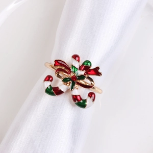Close-up of Christmas candy cane napkin ring with red bow and gold metal finish