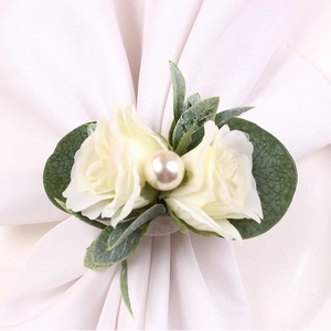 Gros plan du rond de serviette rose blanche avec feuilles et perle pour mariage
