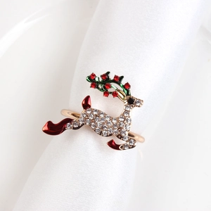 Close-up of golden reindeer napkin ring with rhinestones and enamel on white napkin