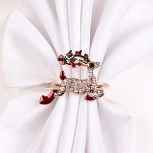 Detail of golden reindeer napkin ring with white rhinestones and red enamel accents