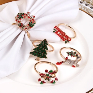 Five-piece Christmas napkin ring set with gold reindeer, tree, and cane designs