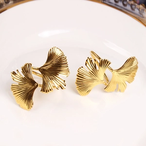 Elegant gold ginkgo leaf napkin rings set of two displayed on a white porcelain dinner plate
