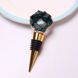 Detail of wine stopper featuring green geode top with gold trim and silicone rings