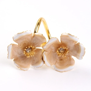 Dual flower napkin ring with gold metal finish and white enamel gradient petals