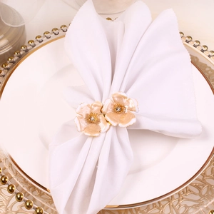 Detail of cream enamel double flower napkin rings with rhinestone center and gold base