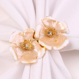 Close-up of floral napkin rings with gradient enamel petals and central zircon stones