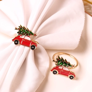Detail of red car and green Christmas tree napkin ring on white fabric background