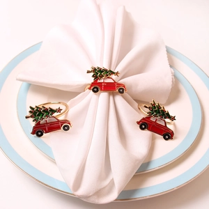 Close-up of red vintage car napkin rings with Christmas tree on a white napkin