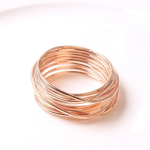 Macro view of multi-layered wire-wrapped rose gold napkin ring with metal wire texture