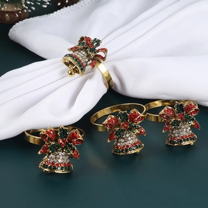 Détail de 4 ronds de serviette cloches de Noël dorés sertis de strass rouges et verts