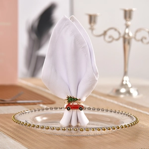 Red retro car with green Christmas tree napkin ring on white dinner cloth