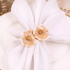 Elegant double cream flower napkin ring with gold edges and crystals on white linen