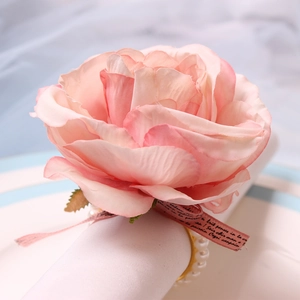 Detail of pink silk rose napkin ring with French script ribbon and white pearl accents