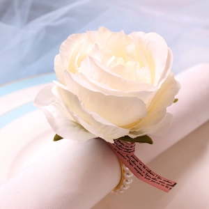 Elegant white rose napkin ring with gold pearl band and decorative pink ribbon accent